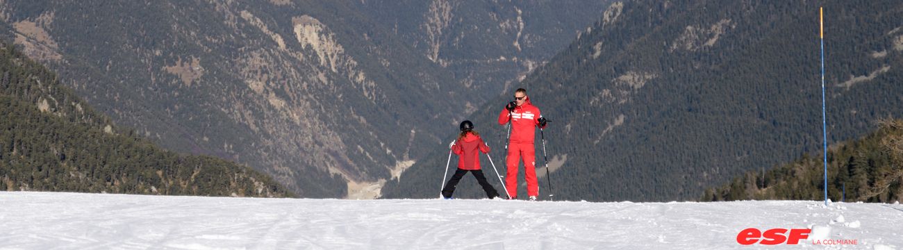 Enfant dérapant en ski sous le regard de son moniteur ESF La Colmiane